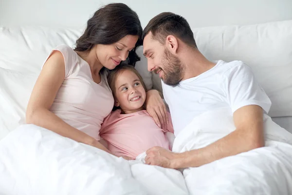 Família feliz na cama em casa — Fotografia de Stock