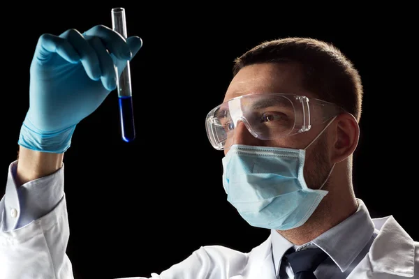 Учёный в защитных очках, маске и пробирке — стоковое фото