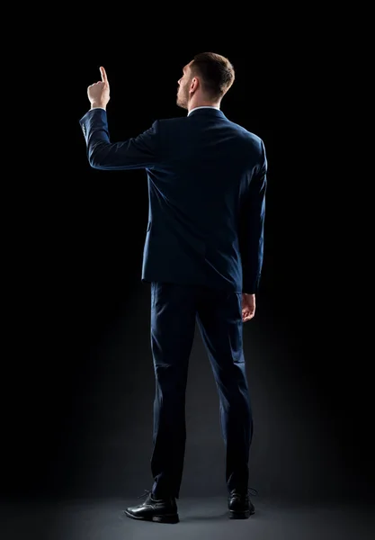 Uomo d'affari in giacca e cravatta toccare qualcosa invisibile — Foto Stock