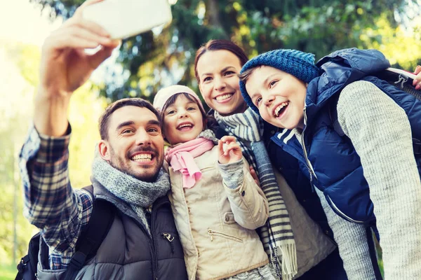 Family with backpacks taking selfie by smartphone — Stock Photo, Image