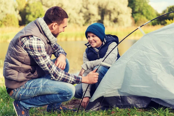 Feliz pai e filho a montar tenda ao ar livre — Fotografia de Stock