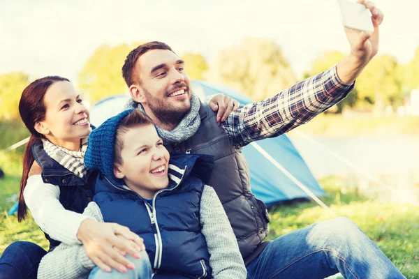 Família com smartphone tomando selfie no parque de campismo — Fotografia de Stock