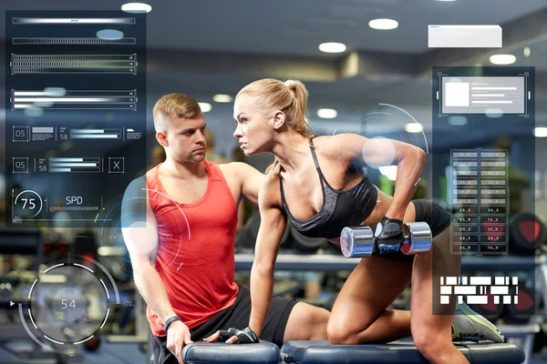 Jeune couple avec haltère flexion des muscles dans la salle de gym — Photo