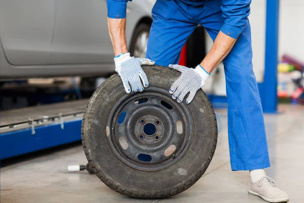 Mekaniker med hjul däck på bilverkstad — Stockfoto