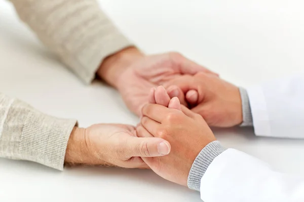 Närbild av läkare håller gamla mannen hand — Stockfoto