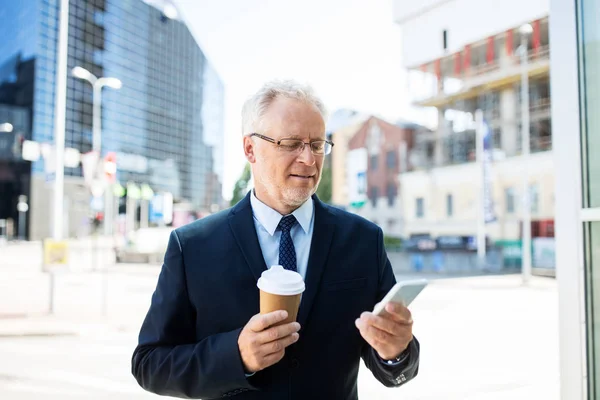 Hombre de negocios con smartphone y café en la ciudad —  Fotos de Stock