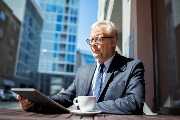 Senior businessman with tablet pc drinking coffee — Stock Photo, Image