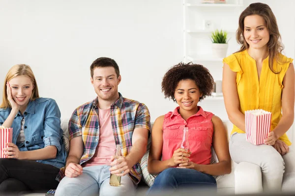 Amigos felices con palomitas de maíz viendo la televisión en casa — Foto de Stock