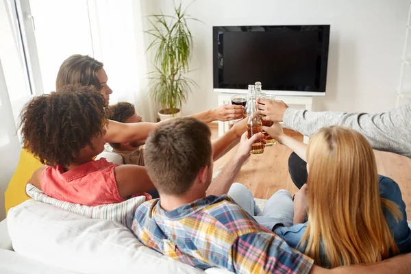 Amigos clinking cerveja e assistindo tv em casa — Fotografia de Stock