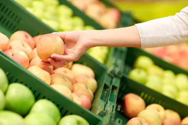 Hand with apples at grocery store — Stock Photo, Image