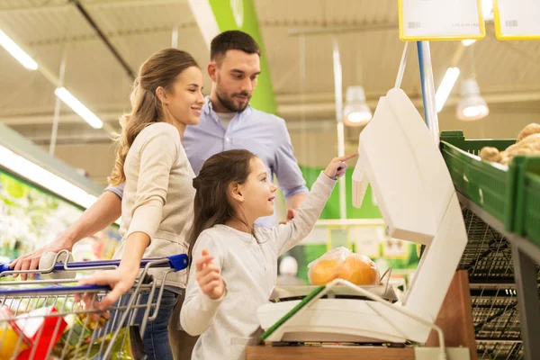 Famiglia che pesa arance in scala al supermercato — Foto Stock