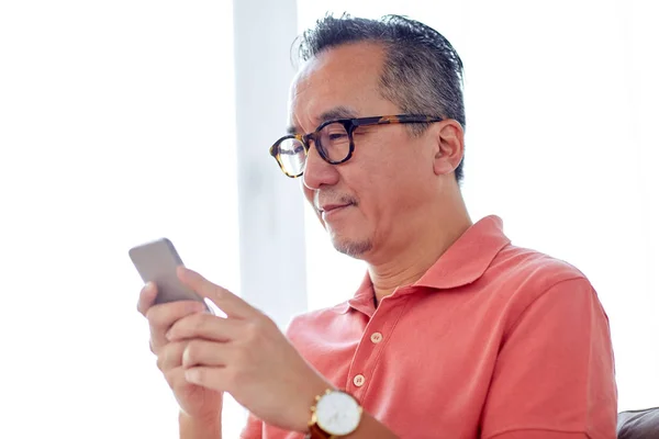 Man met smartphone zittend op de Bank thuis — Stockfoto