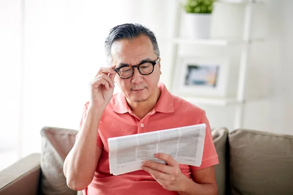 Pria bahagia berkacamata membaca koran di rumah — Stok Foto