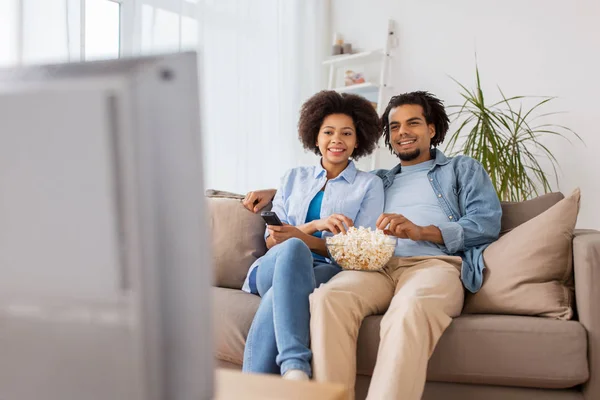 Sonriente pareja con palomitas de maíz viendo tv en casa — Foto de Stock