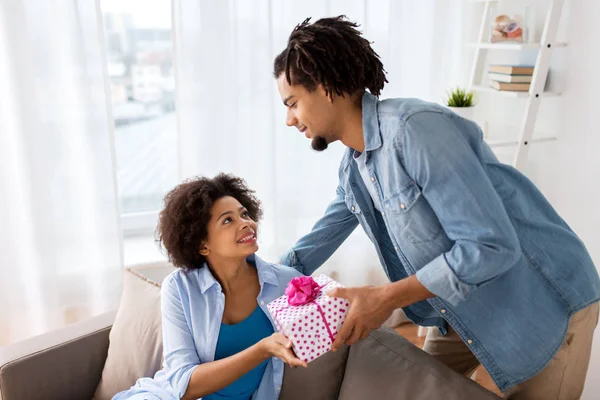 Feliz pareja con caja de regalo en casa — Foto de Stock