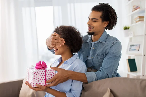 Feliz pareja con caja de regalo en casa — Foto de Stock