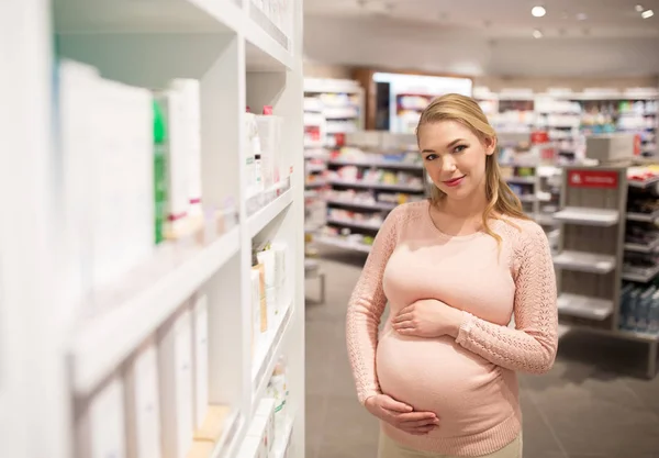 Mujer embarazada en farmacia o tienda de cosméticos —  Fotos de Stock