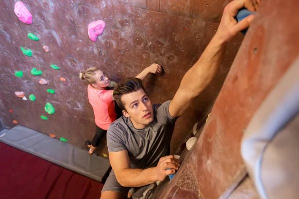 Homem e mulher se exercitando no ginásio de escalada indoor — Fotografia de Stock