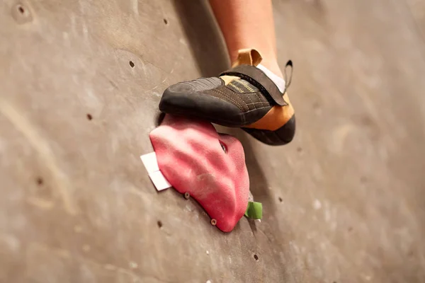 Foten av kvinna på klättervägg inomhus med gym håller — Stockfoto
