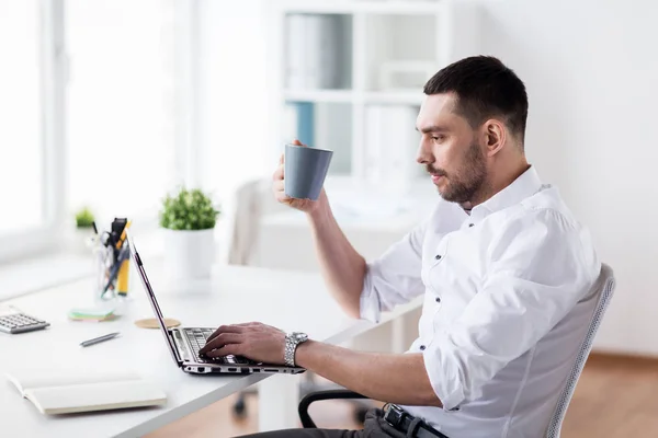 Hombre de negocios con café escribiendo en el ordenador portátil en la oficina —  Fotos de Stock