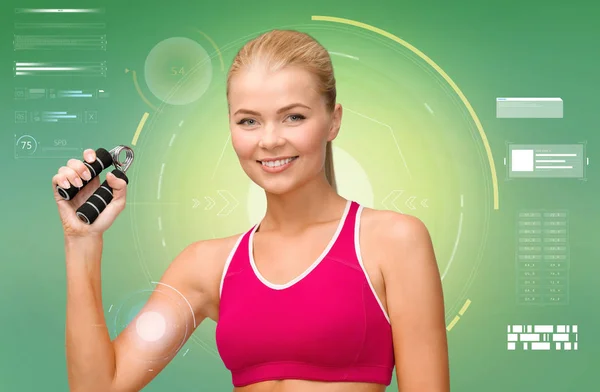Sportovní žena s expandér nad zeleným pozadím — Stock fotografie
