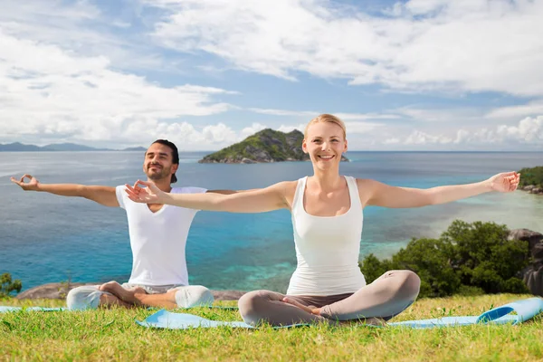 Casal feliz fazendo exercícios de ioga ao ar livre — Fotografia de Stock