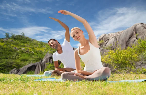 Cuplu zâmbind făcând exerciții de yoga în aer liber — Fotografie, imagine de stoc
