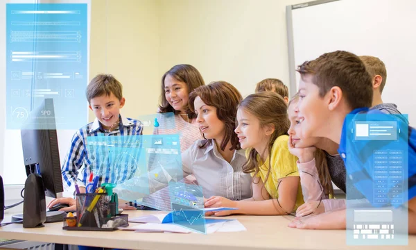 Groep van jonge geitjes met leraar en computer op school — Stockfoto