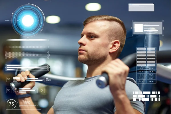 Hombre ejercitando y flexionando los músculos en la máquina de gimnasio —  Fotos de Stock