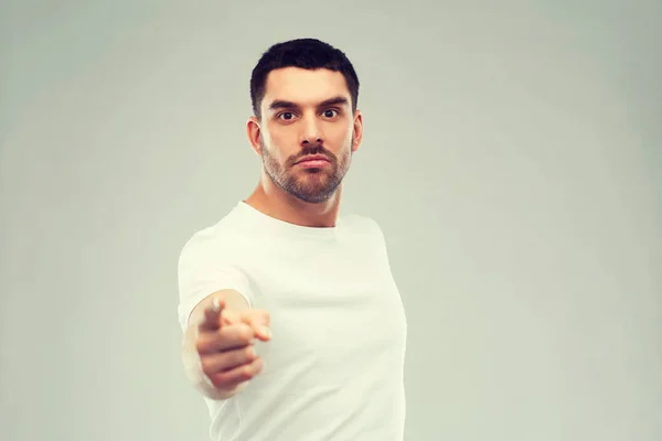 Angry man pointing finger to you over gray Stock Picture