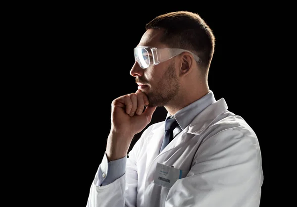 Doctor or scientist in lab coat and safety glasses — Stock Photo, Image