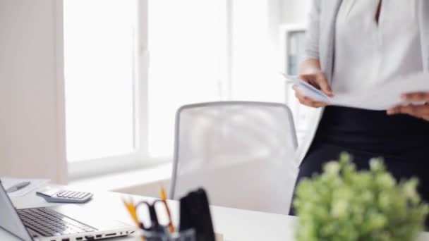 Businesswoman with laptop and papers at office — Stock Video