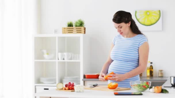 Pregnant woman cooking vegetable salad at home — Stock Video