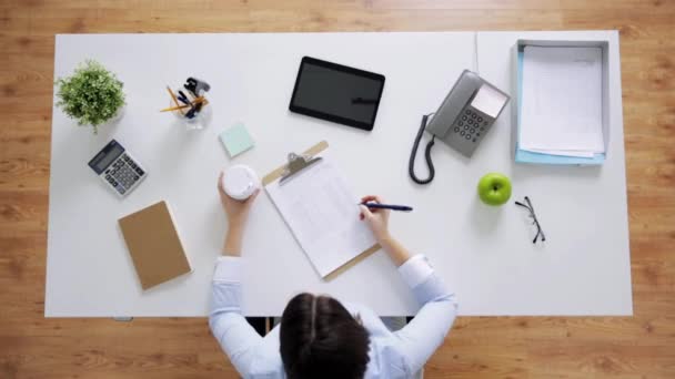 Affärskvinna med papper och kaffe på kontoret — Stockvideo