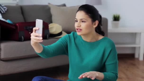 Mujer con teléfono inteligente y cosas de viaje en casa — Vídeo de stock