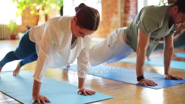 Gruppe von Leuten, die Yoga-Übungen im Fitnessstudio machen — Stockvideo