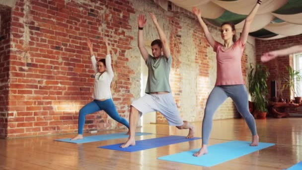 Gruppe von Leuten, die Yoga-Übungen im Fitnessstudio machen — Stockvideo