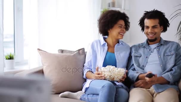 Χαμογελώντας ζευγάρι με ποπ κορν βλέποντας τηλεόραση στο σπίτι — Αρχείο Βίντεο