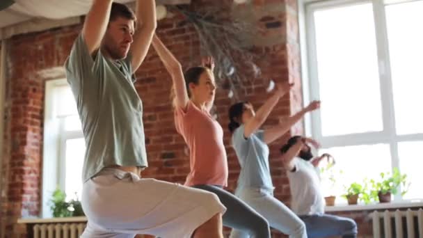 Group of people making yoga exercises in gym — Stock Video