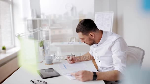 Businessman with tablet pc and papers at office — Stock Video