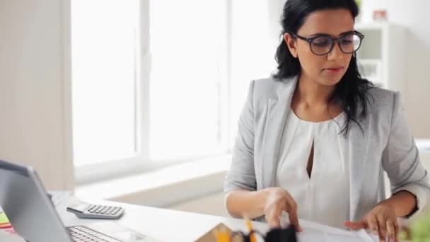 Businesswoman with laptop and papers at office — Stock Video