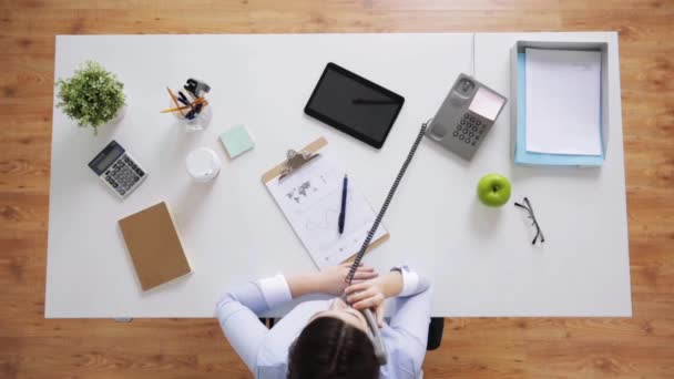 Businesswoman calling on phone at office desk — Stock Video