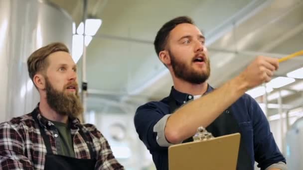 Άνδρες με πρόχειρο στο εργοστάσιο ζυθοποιίας ή μπύρα — Αρχείο Βίντεο