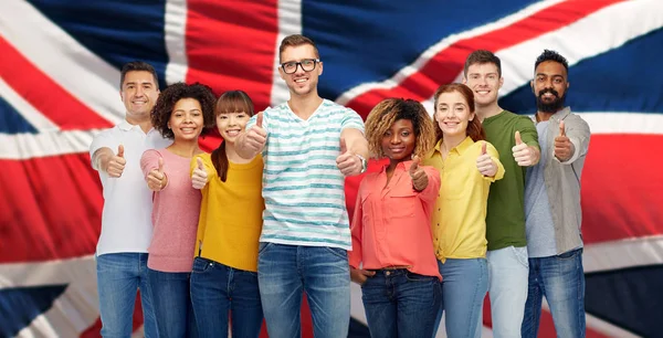 Pessoas mostrando polegares para cima sobre bandeira inglesa — Fotografia de Stock