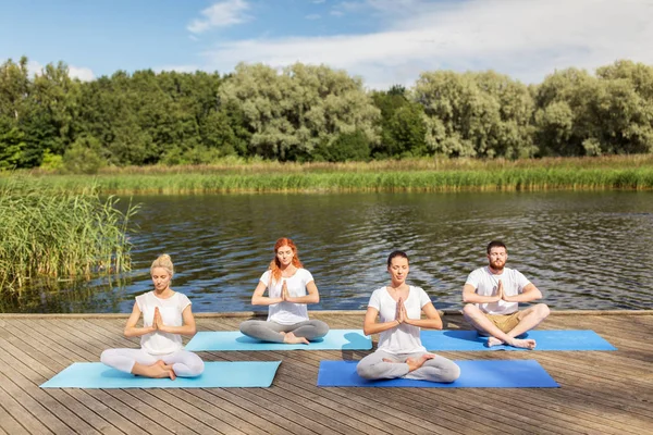 Mensen mediteren in yoga lotus pose buitenshuis — Stockfoto