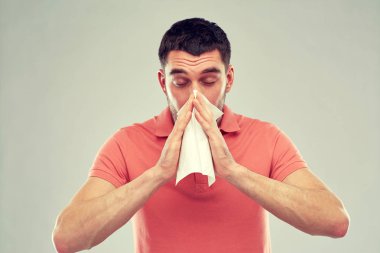 sick man with paper napkin blowing nose clipart