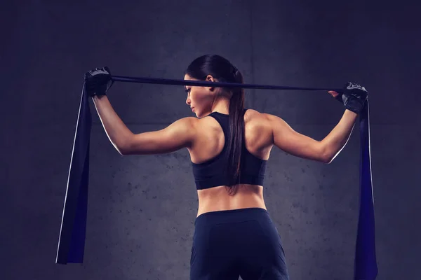 Mujer con expansor haciendo ejercicio en el gimnasio — Foto de Stock