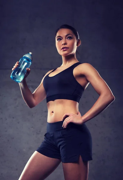 Žena pitnou vodu z láhve v tělocvičně — Stock fotografie