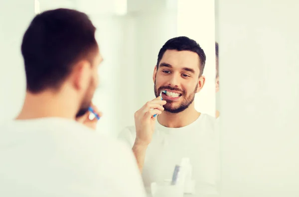 男人用牙刷清洁牙齿在浴室 — 图库照片