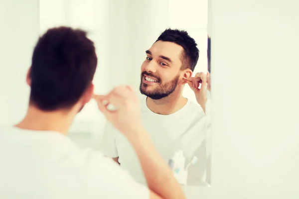 Uomo pulizia orecchio con tampone di cotone in bagno — Foto Stock